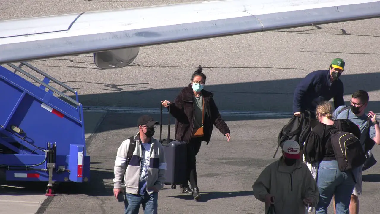 people exiting airplane after long flight