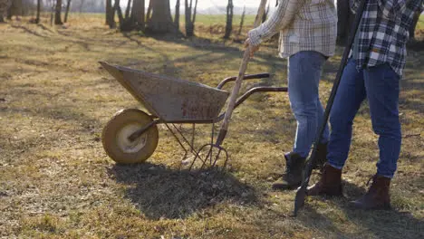 Caucasian couple removing weeds with a rake in the countryside