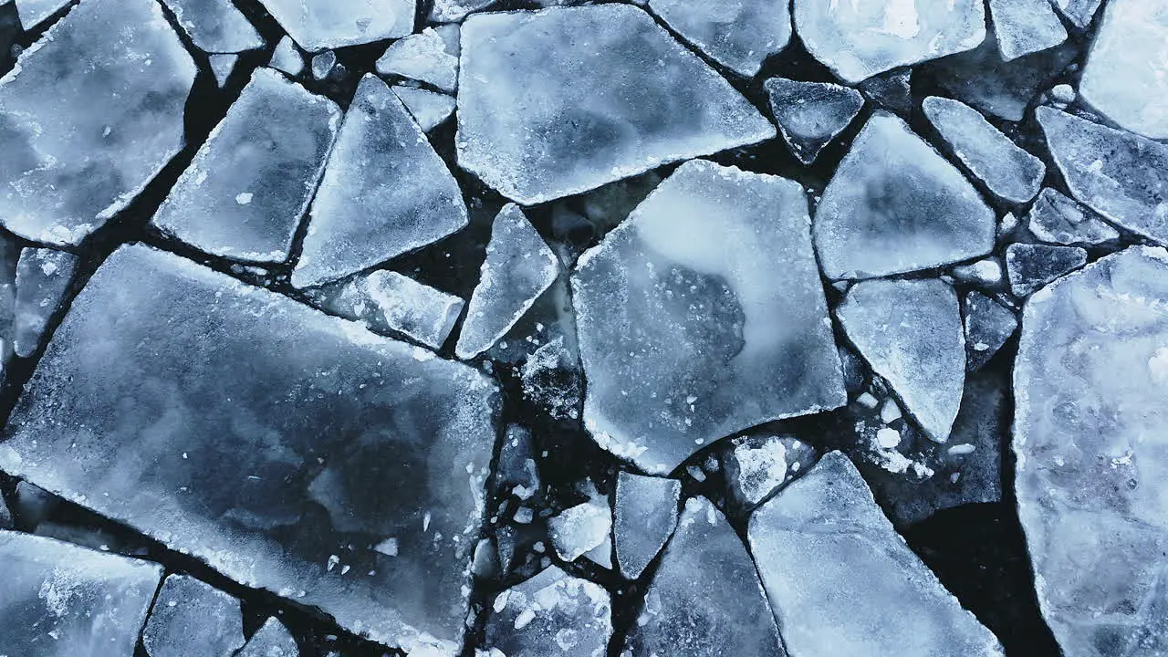 Drone shot panning around showing huge chunks of frozen ice in Lake Michigan looking straight down