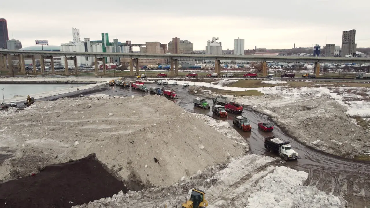 29 December 2022 Aerial Flying Over Snow Storage Site With Queues Of Trucks Lining Up Beside Buffalo Highway In New York