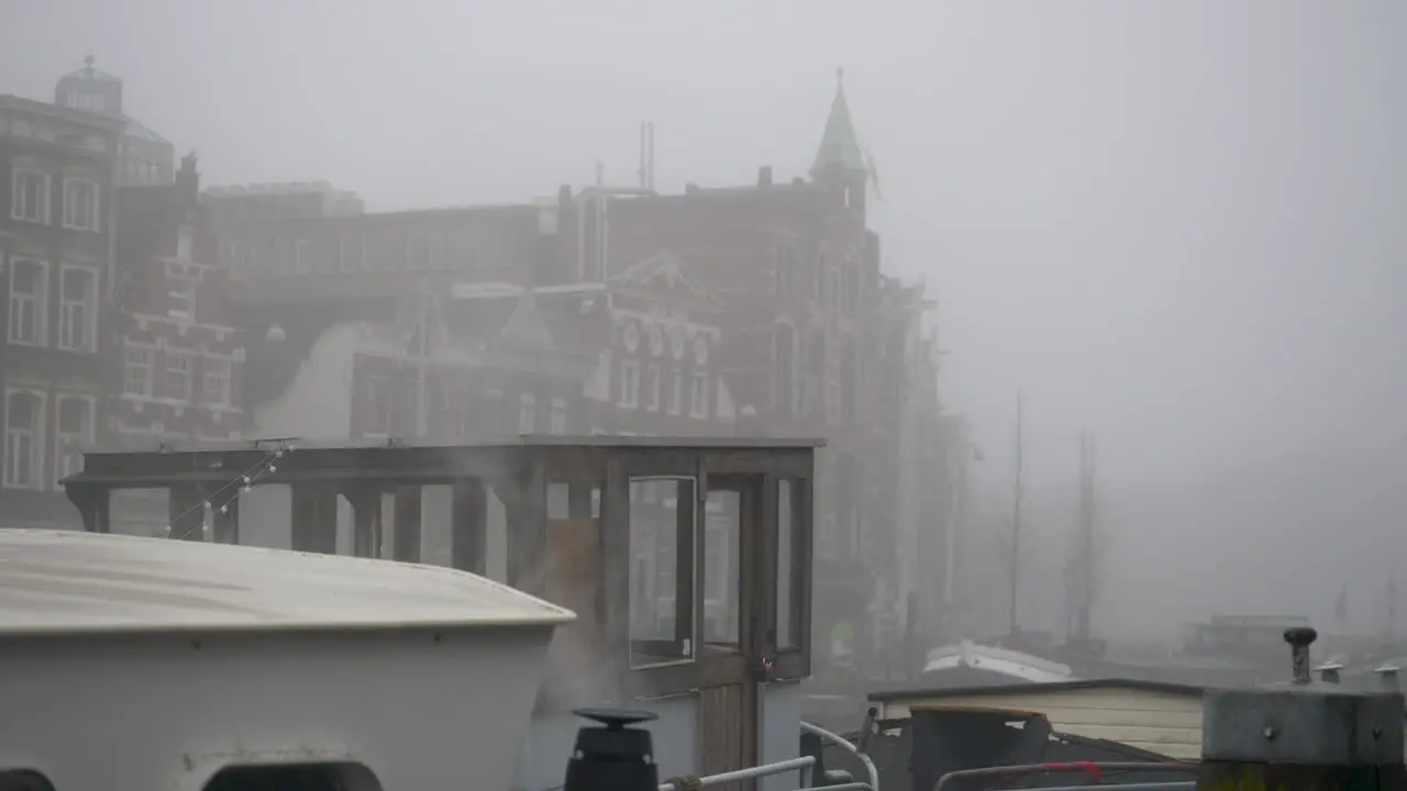 Steam coming from the outlet of a hosueboat moored in a canal on a misty day in Amsterdam