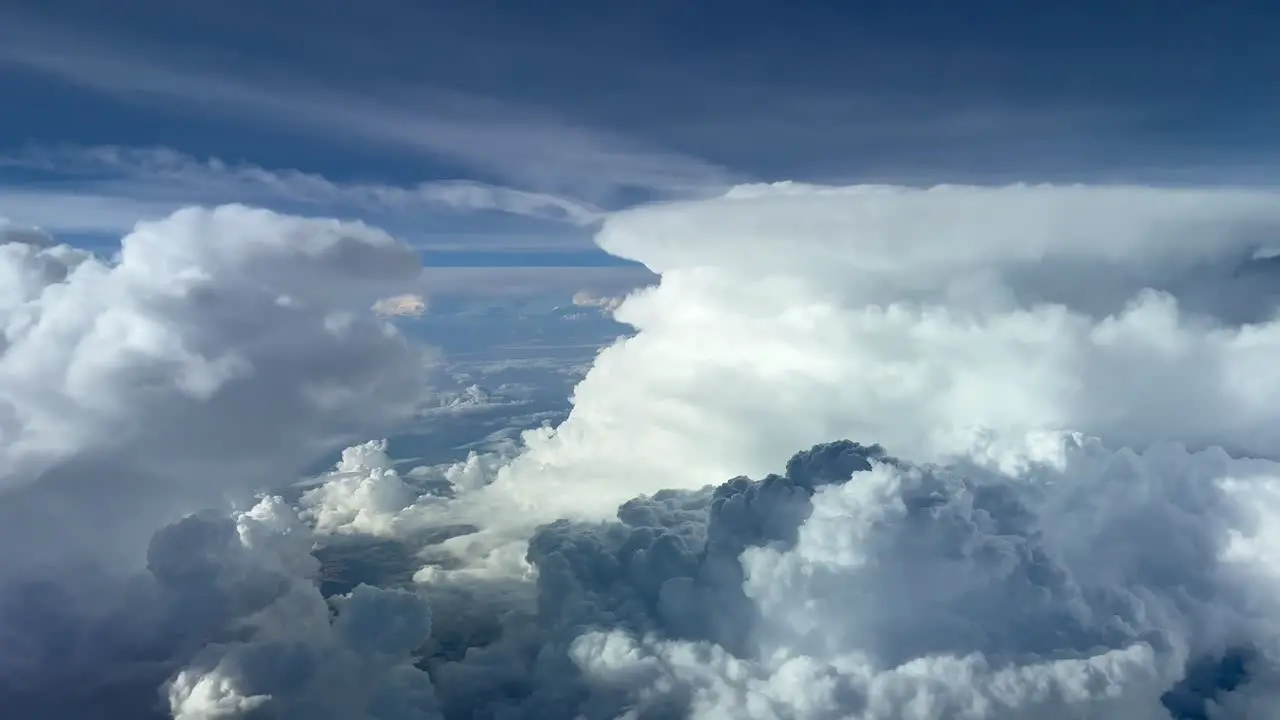 Amazing aerial view from a jet cockpit while flying at 12000 metres high of some huge cumuloninmus ahead