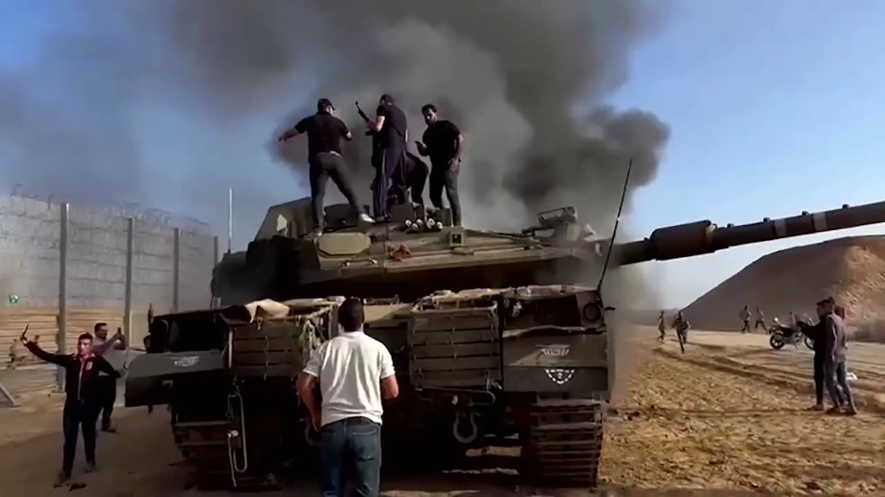 Palestinians on destroyed Israeli military tank at the Gaza Strip fence Al Aqsa flood operation by Hamas 10-07-2023