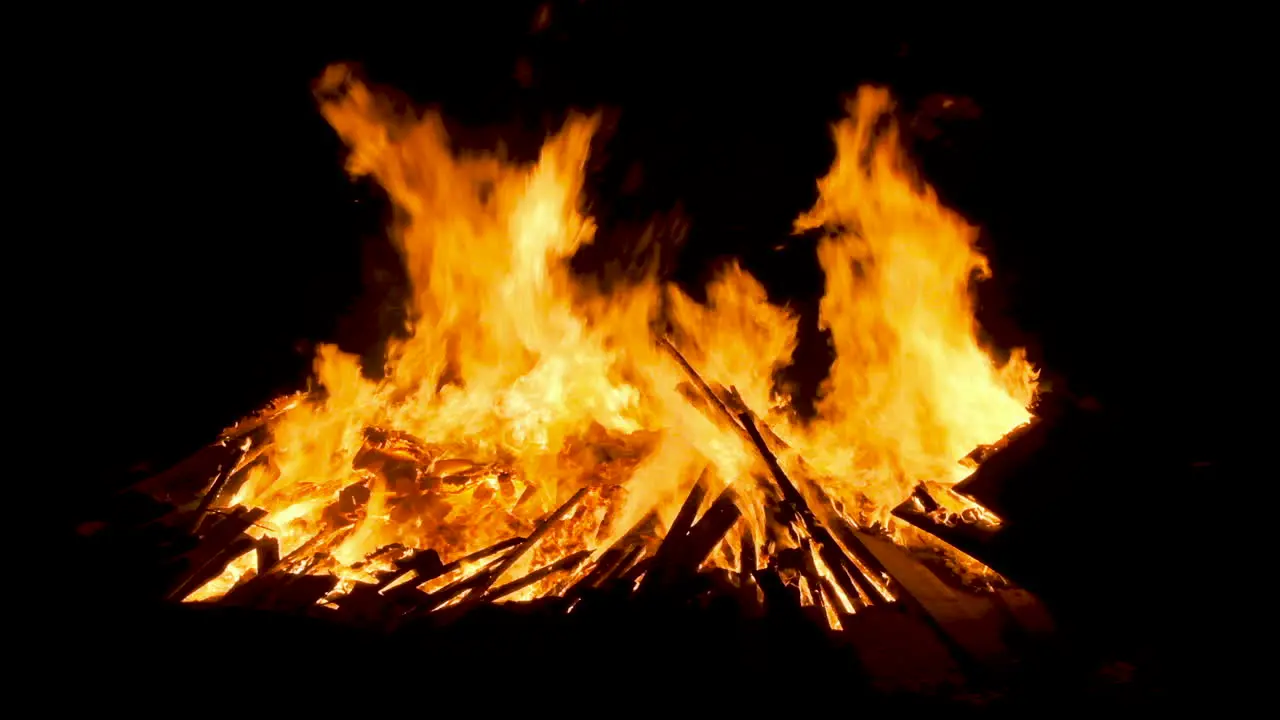 Close up of a large bonfire on the beach at night