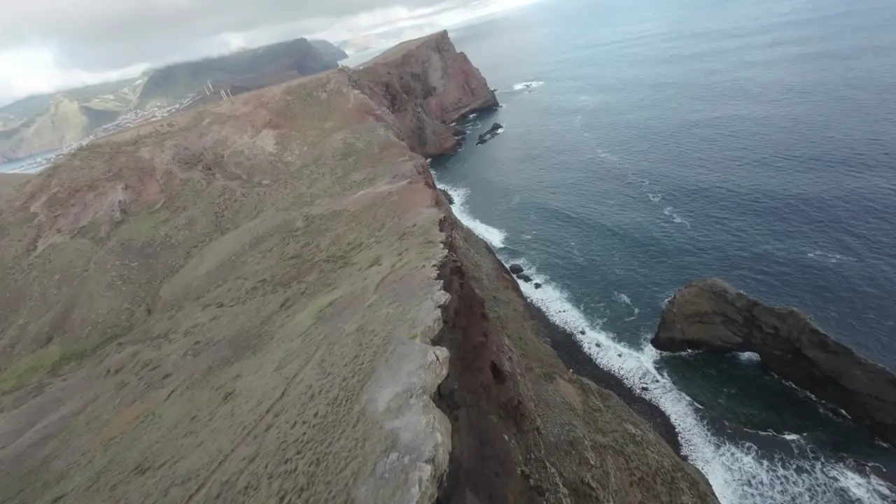 flying above a small lighthouse on the cliffs of madeira island