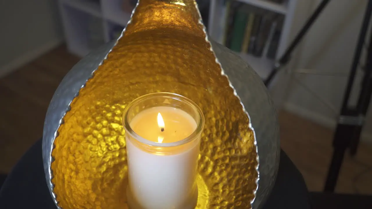 Slow slider shot of candle glowing in orb candle holder peaceful