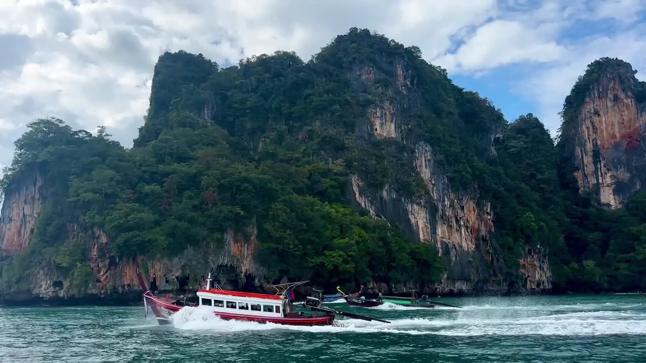  A boat speeds to the right while two others swiftly pass to the left in front of it