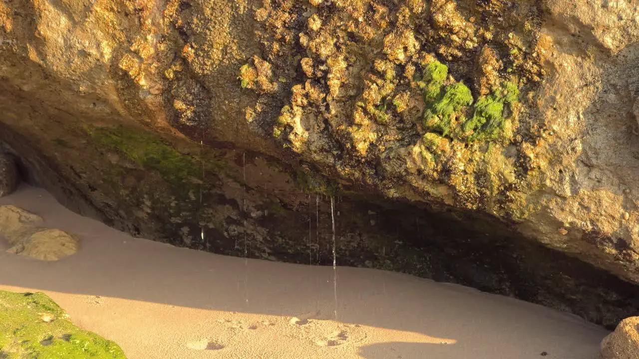 Water cascades from rocky structures showering droplets upon the stony surface