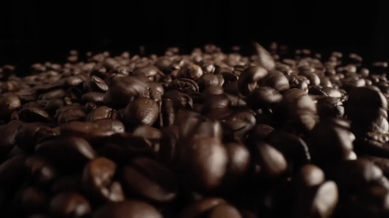 Zoom out macro video of falling coffee beans