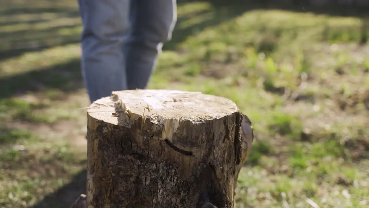 Close-up view of caucasian man chopping firewood with an ax outside a country house Then he looks at camera