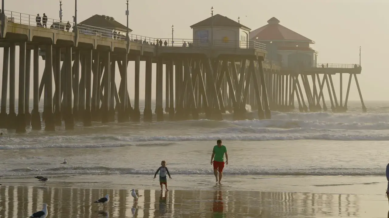 Family next to the Huntington Beach Pier at sundown