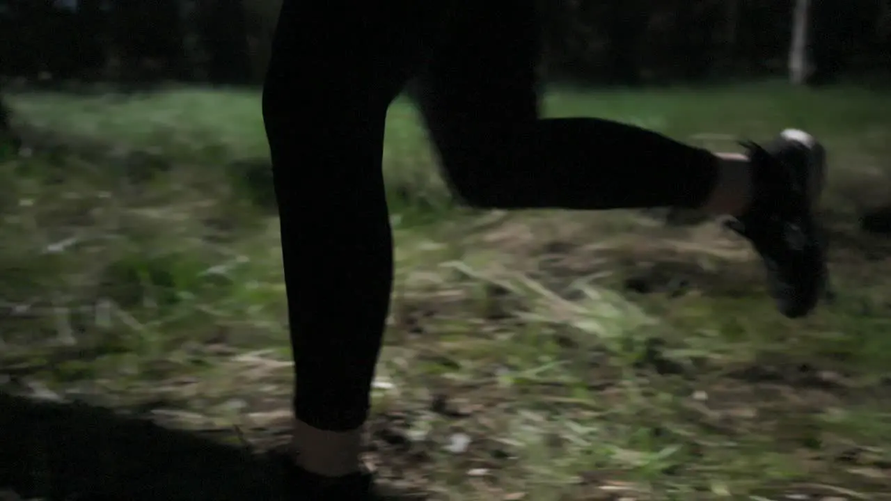 A slow motion shot of a sneaker runner running in the woods the sun and shadows creating a cinematic atmosphere among the pines