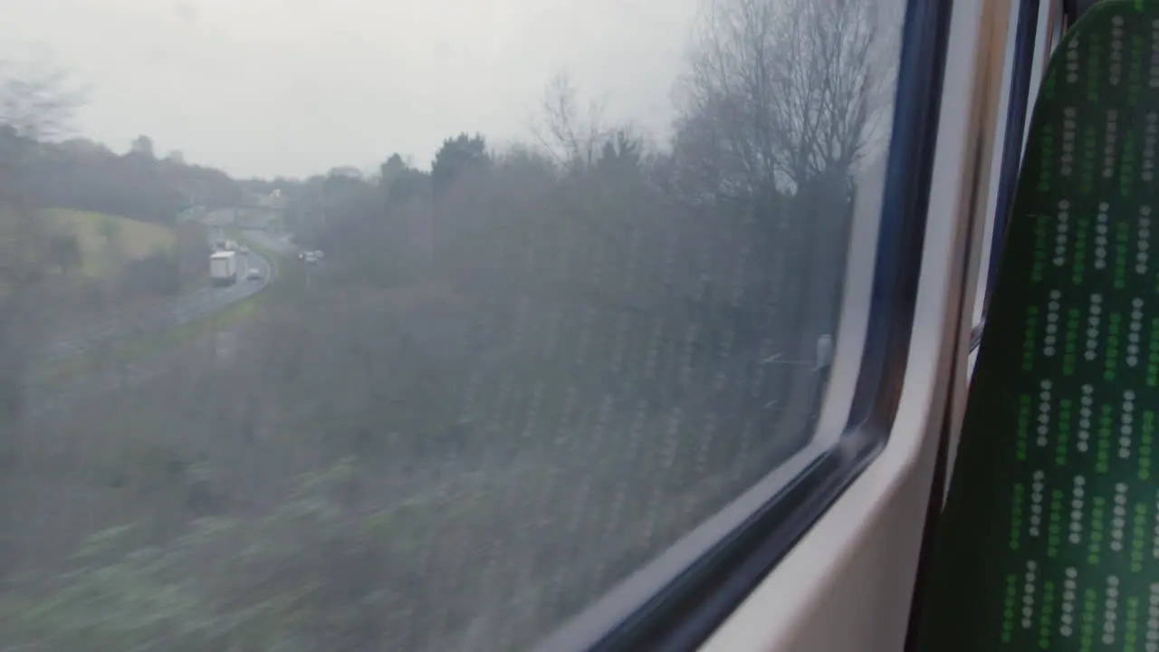 Looking out train window passing road with traffic