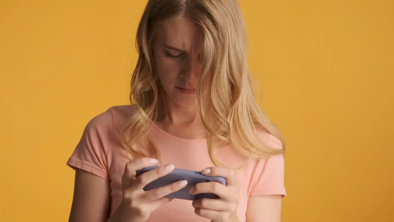 Caucasian woman playing video games on smartphone