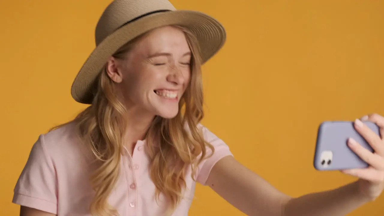 Caucasian woman in a hat having video call on smartphone