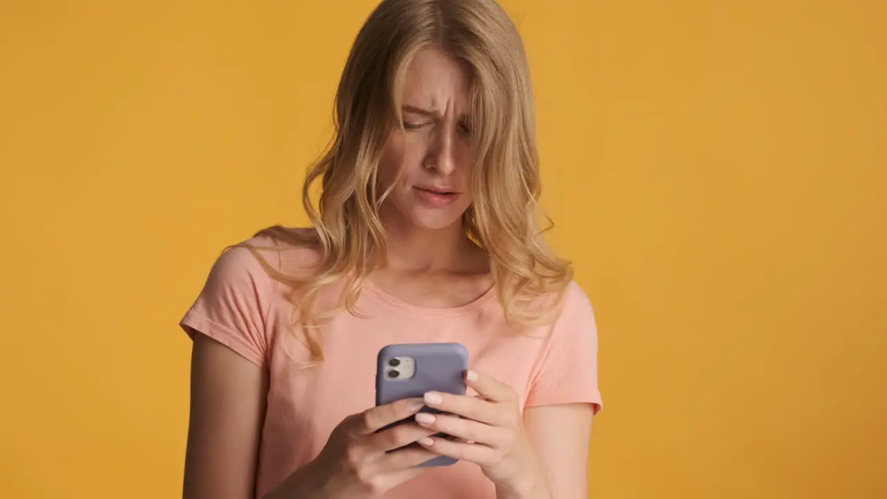 Caucasian woman using smartphone and getting upset on camera