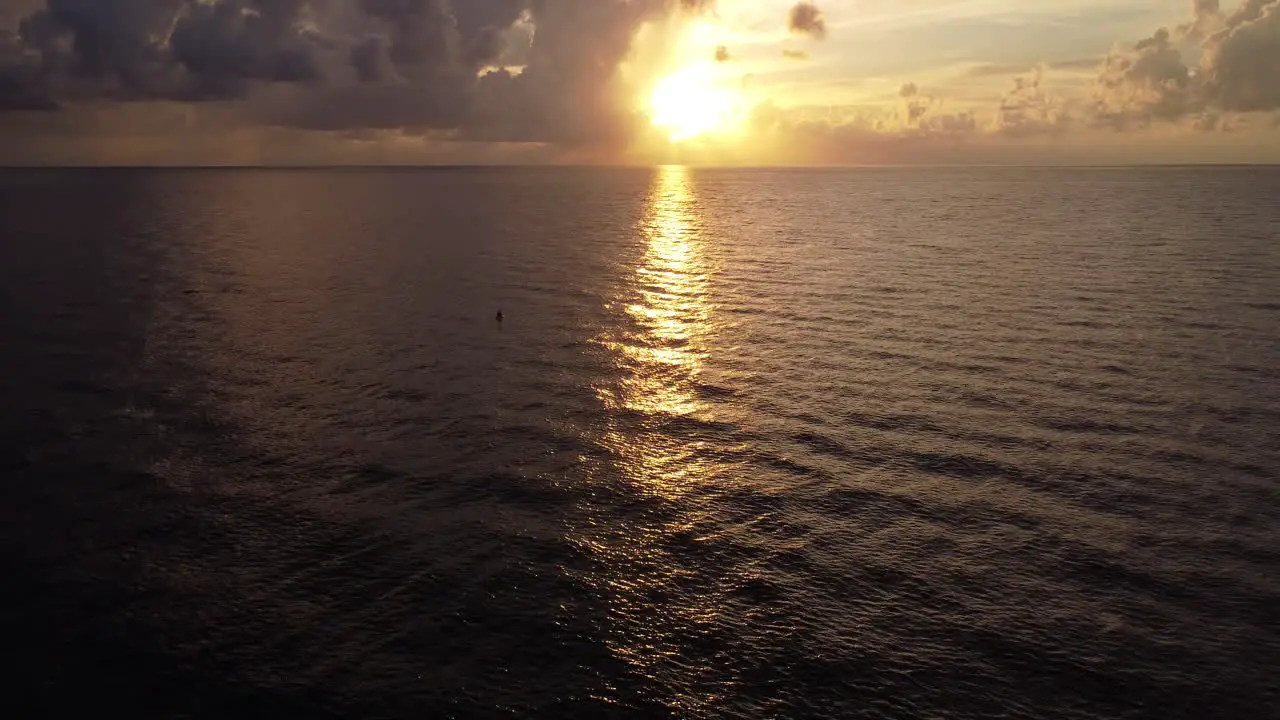 A Scenic Sunrise or Sunset Over the Ocean with a View of the Horizon from an Aerial Drone Shot Flying Toward the Sunlight