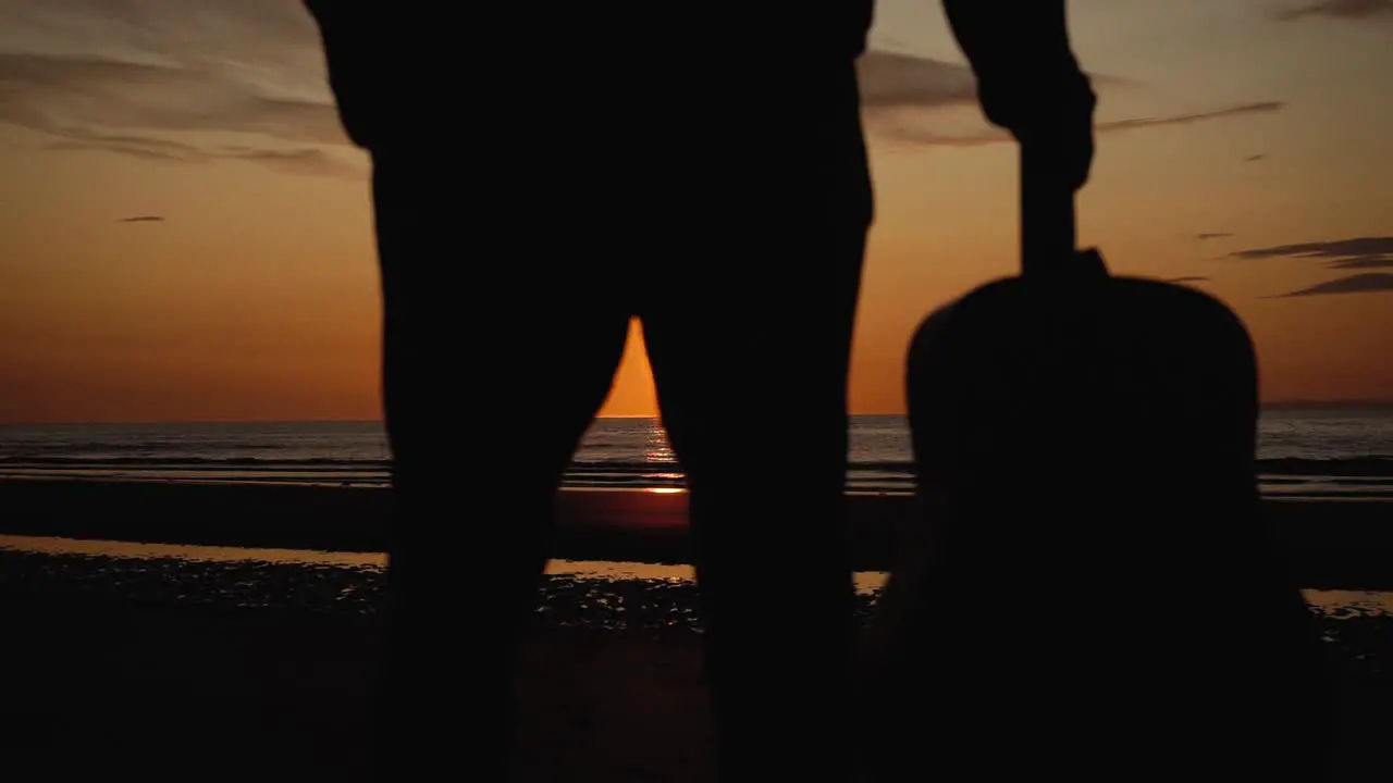 Man running with guitar in back sand beach at sunset-26