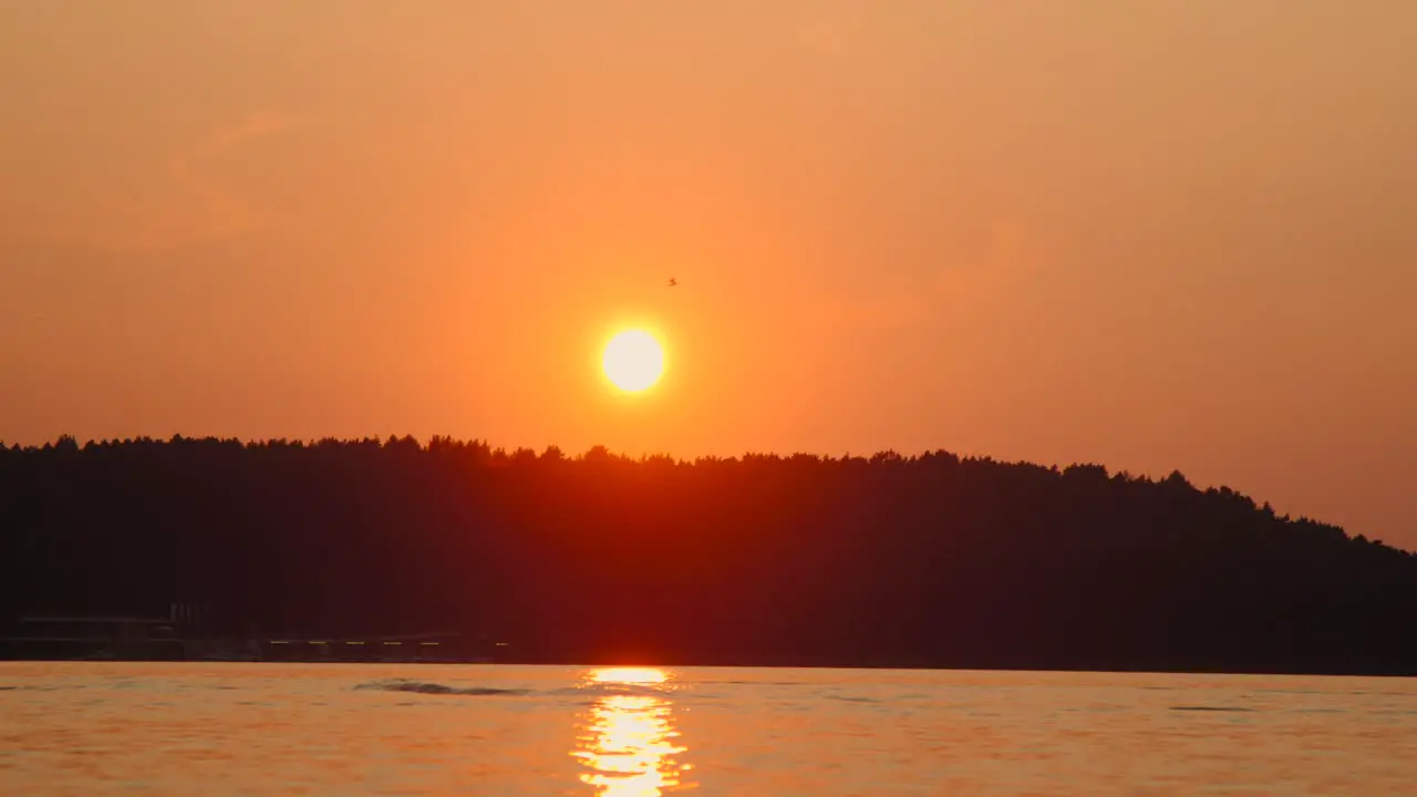 Majestic summer sunset lake hang glider