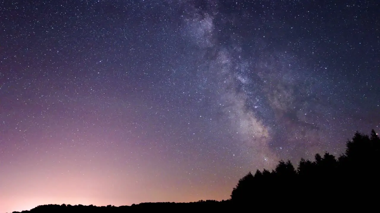 Time lapse of the Milky Way with silhouette of ridge-line and trees