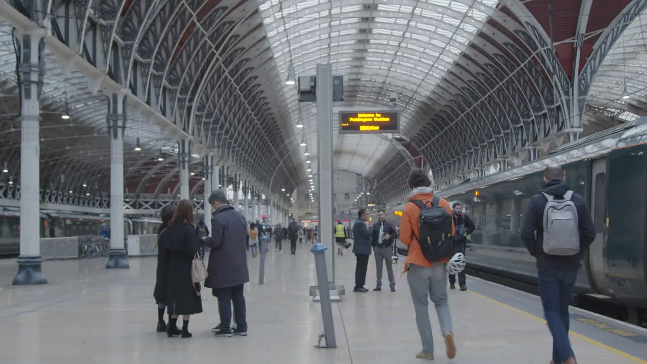 Passengers walk along platform at London Paddington Station