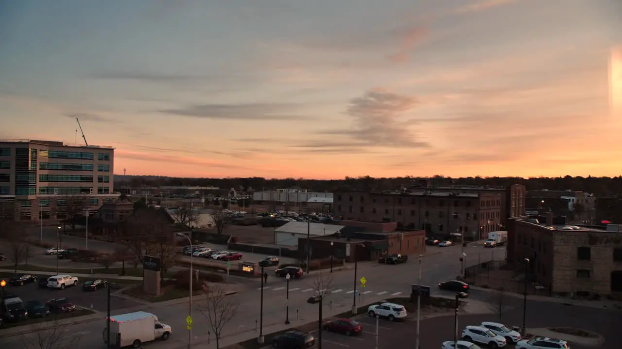 4k Exterior downtown street at sunset with cars driving by busy intersection golden hour orange sky in Sioux Falls South Dakota