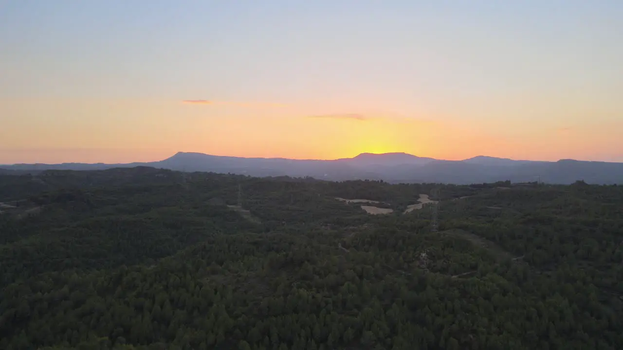 Aerial views of a sunset with the mountains and windmills in the background