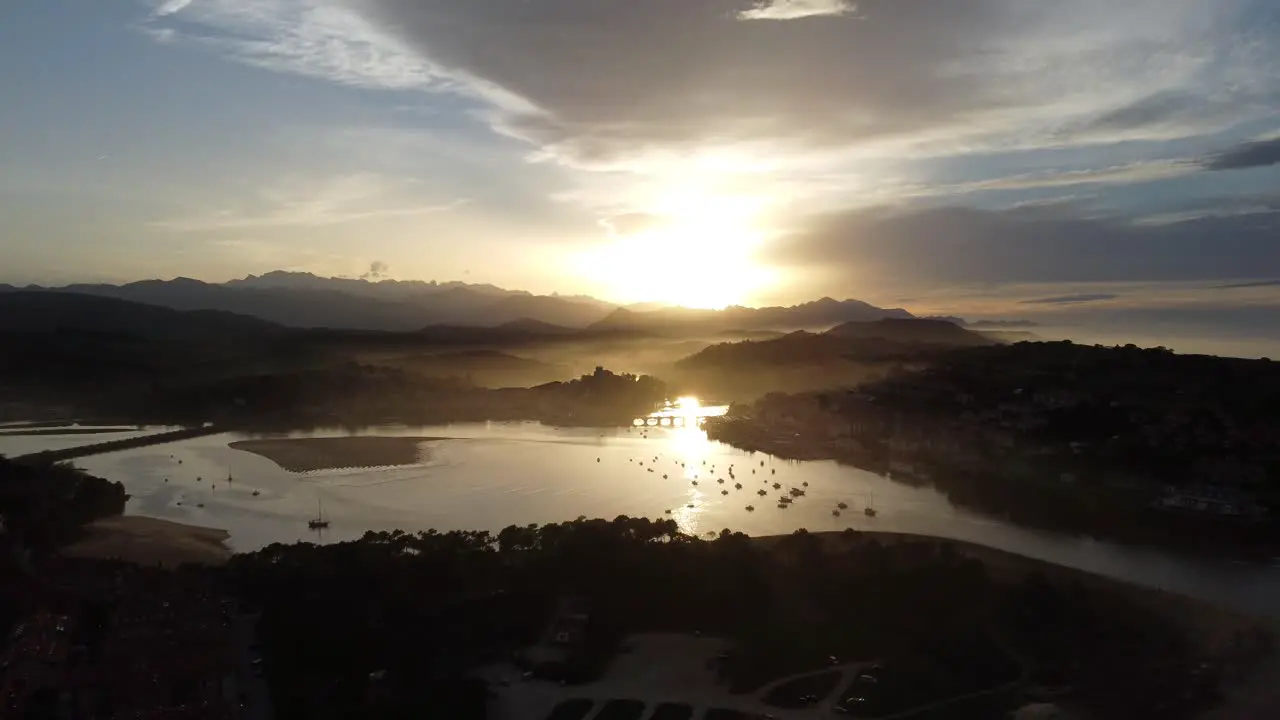 the amazing town of san vicente de la barquera in cantabria in northern spain in front of a stunning sunset with fog and clouds drone