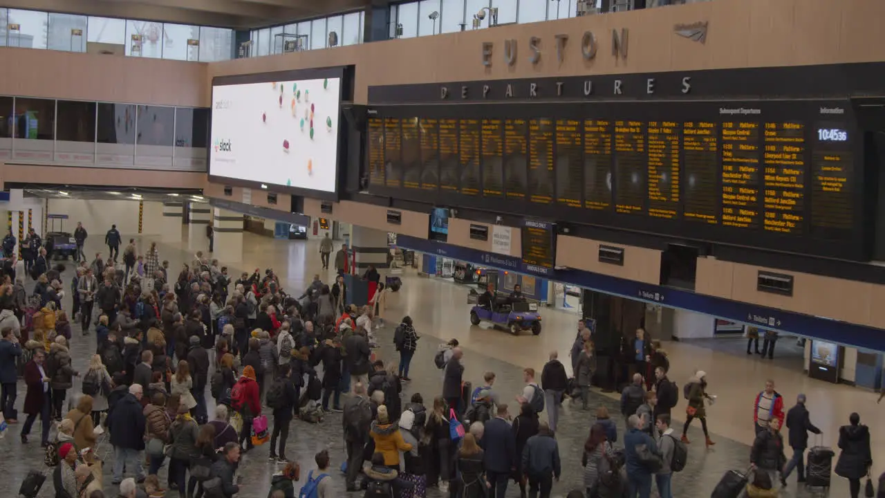 Wide shot of people leaving train station concourse