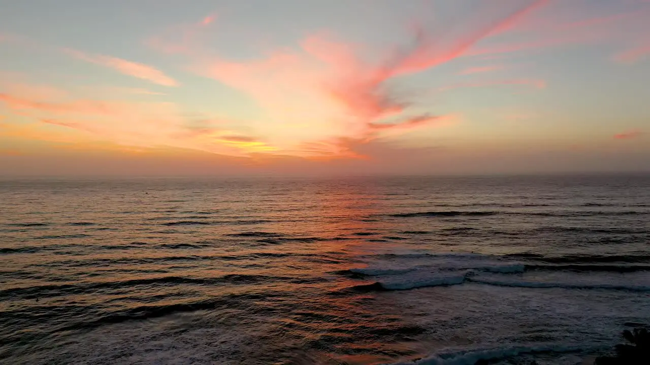 Sunset aerial view of waves crashing on beautiful beach in San Diego California