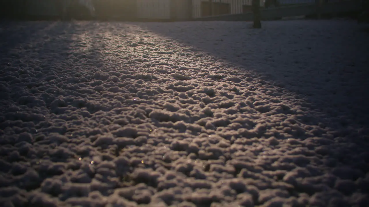 Wide shot of snow in the garden sun hitting parts of the snow creating a pocket of light