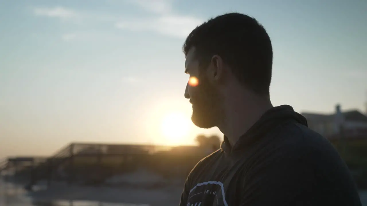 Young man silhouette looking into the sunset at Folly Beach South Carolina