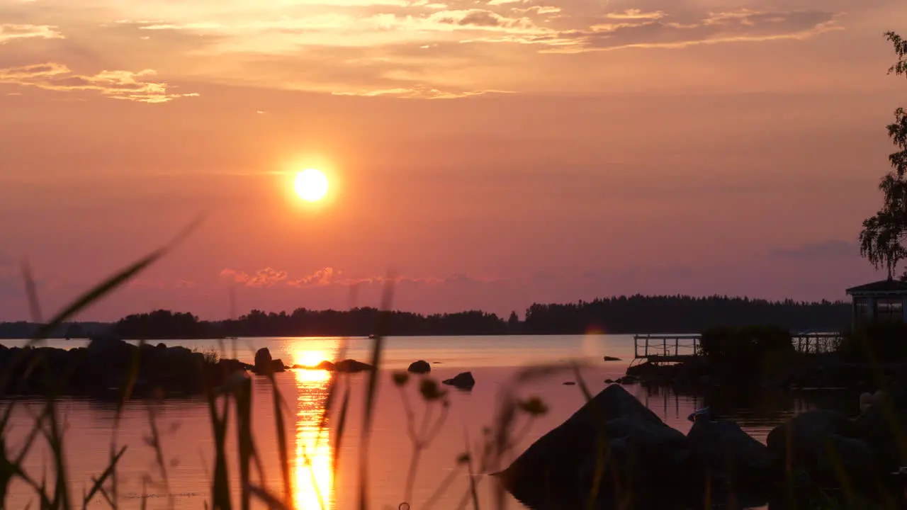 Lakeside and silhouetted landscape at pink sunset