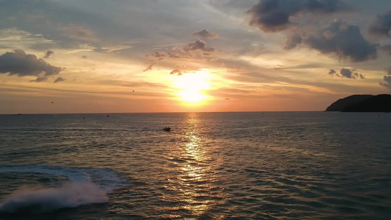 Aerial drone shot of beautiful sunset reflecting in the ocean at Pantai Cenang in Langkawi Malyasia