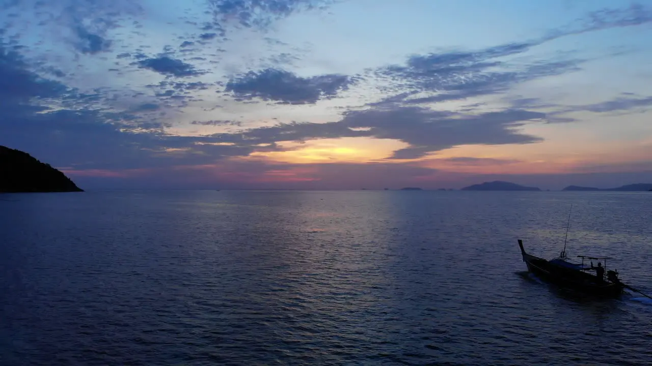 A Thai tale boat sailing towards the sunset