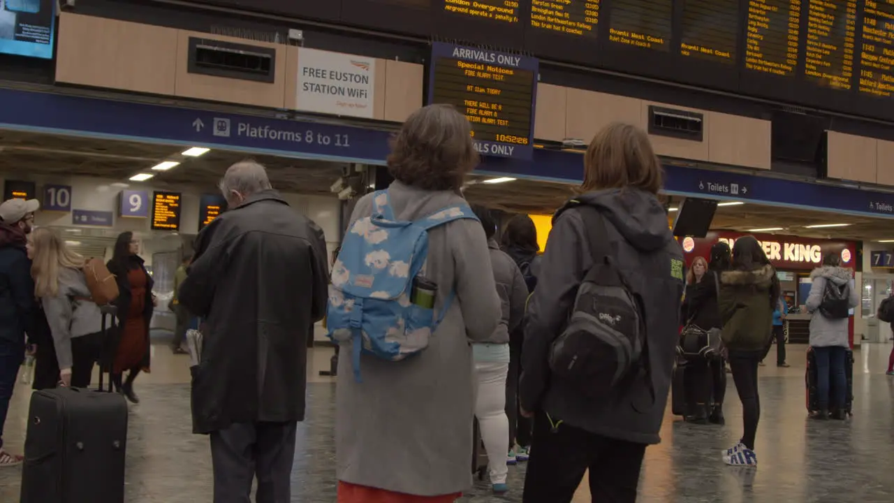 Two women watching the train departure board