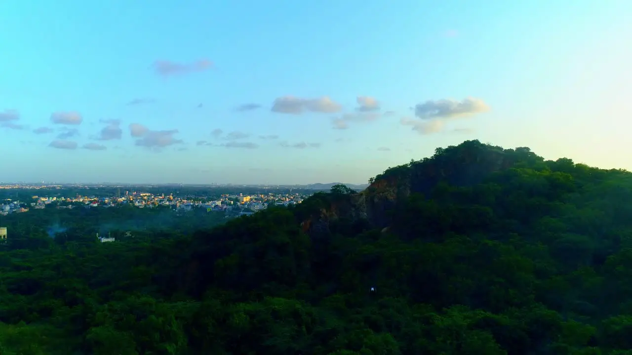 Drone shot rising with a mountain in the backdrop showing another drone flying downwards