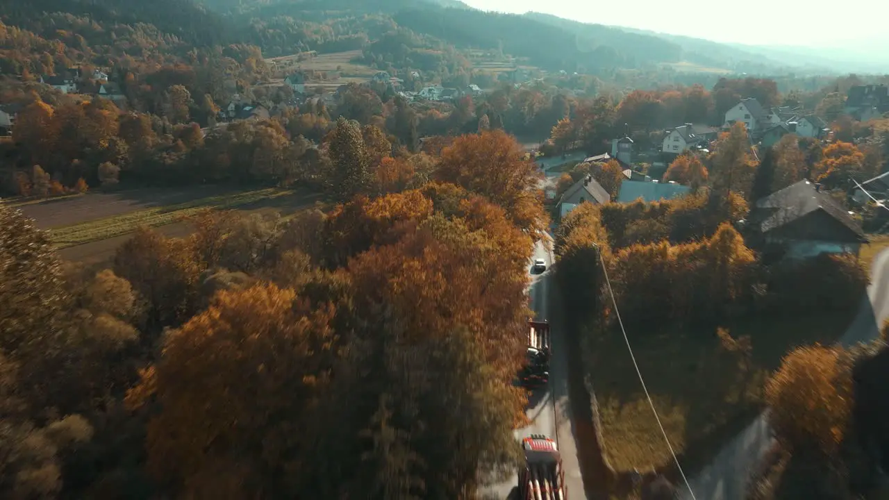 Aerial shot of timber trucks convoy in autumn season