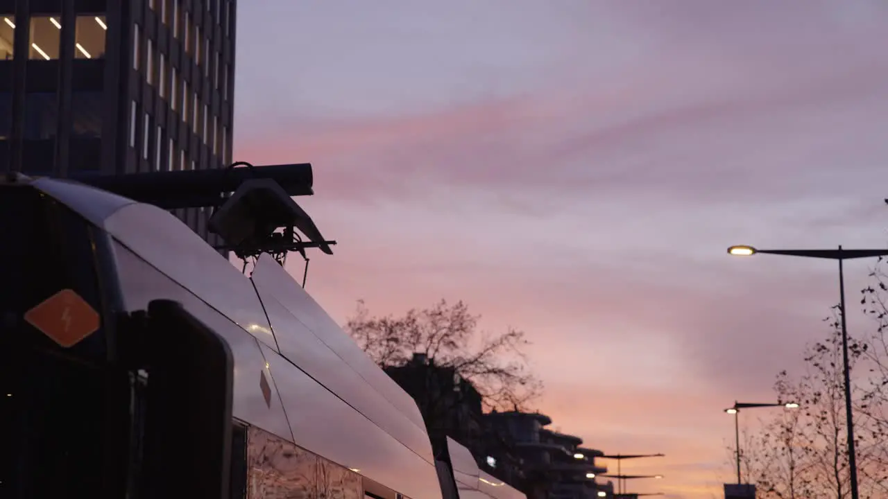 Electric bus charging renewable electricity at beautiful sunset