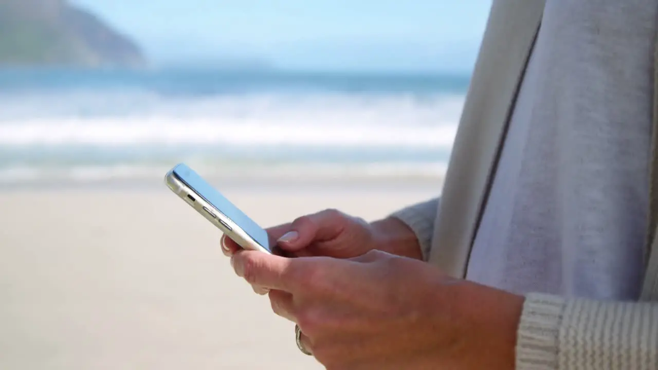 Mid-section of woman using mobile phone