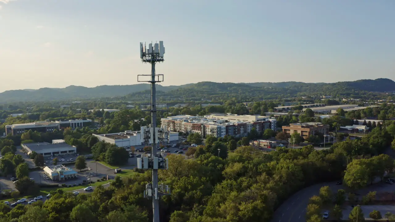 Aerial view passing by 5G cell phone radio communications tower 4K