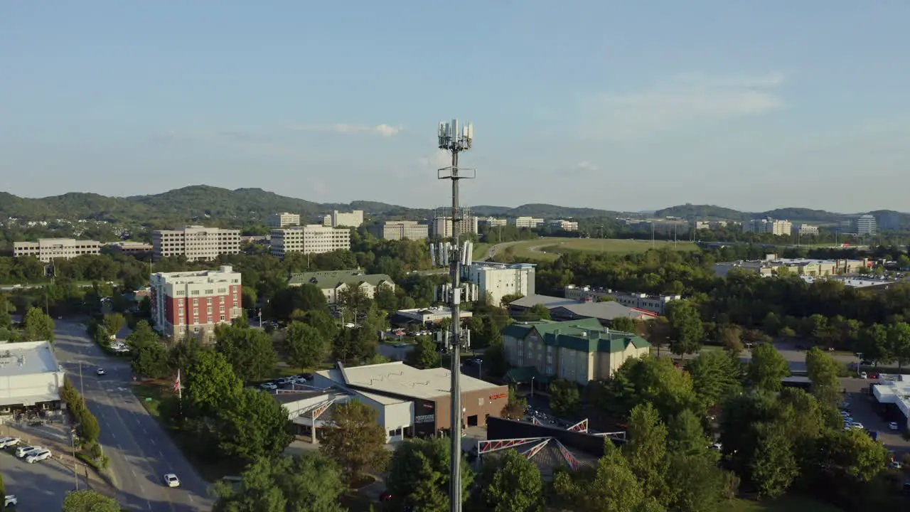 4K aerial of 5G cell phone radio communication tower in busy suburban area