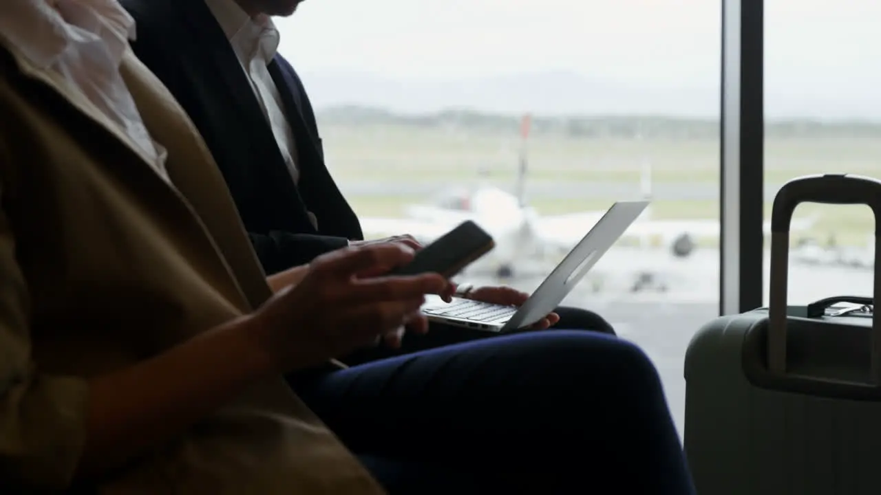 Passengers using laptop and mobile phone