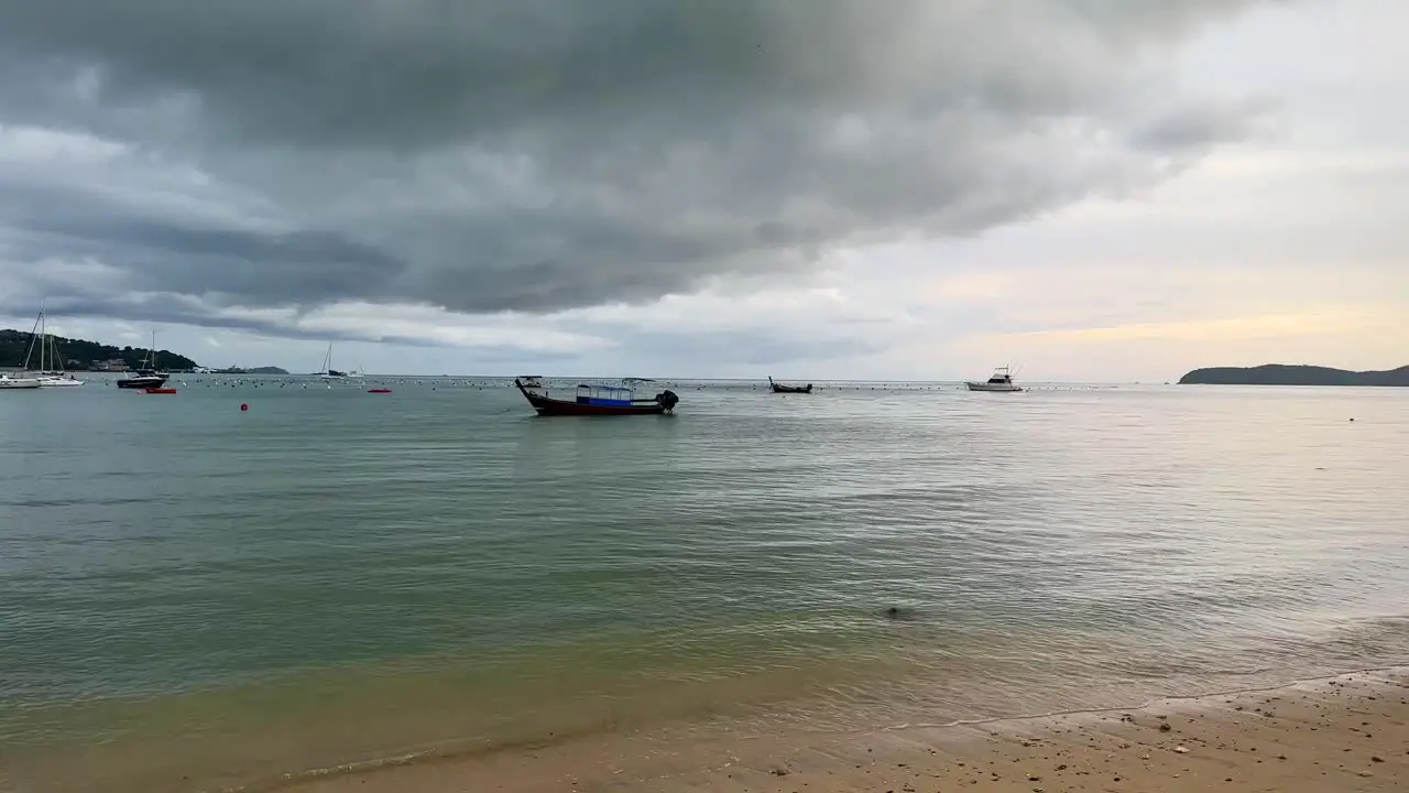 Beach at sunset with anchored boats in Phuket Thailand