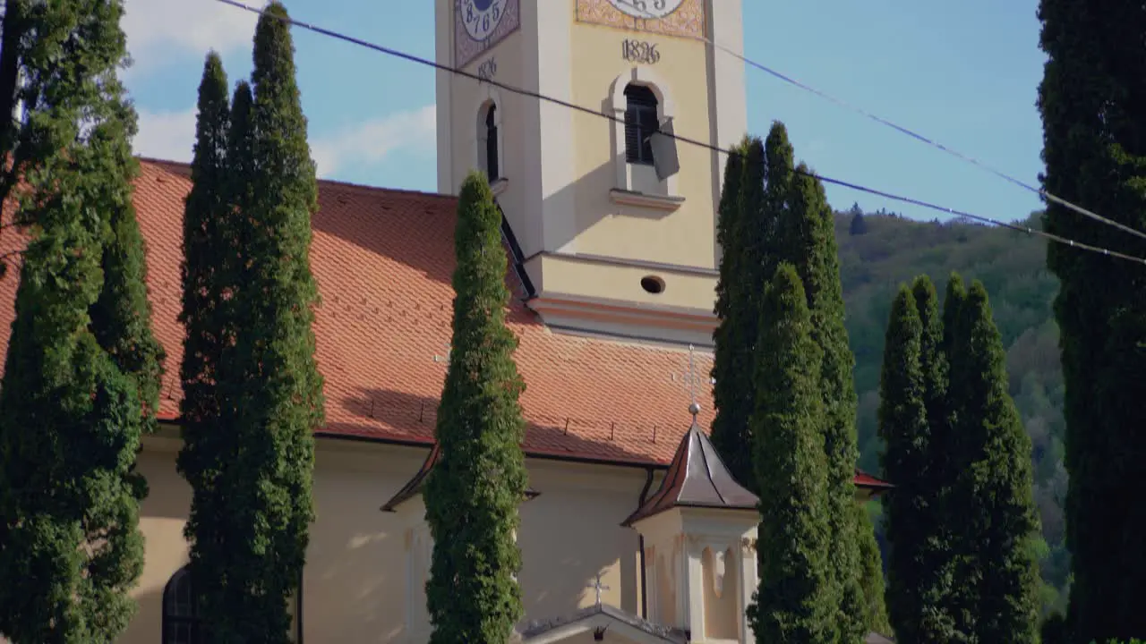 Pan up camera movement revealing a church with a clock tower at Brasov Romania