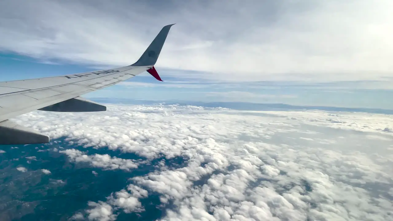 shot of window seat over clouds over cumulus nimbus clouds