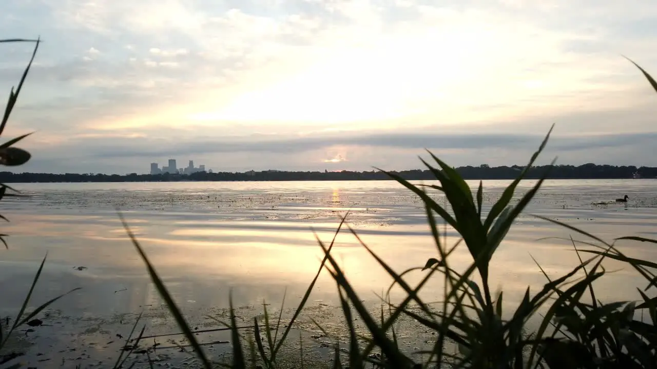 time lapse during a cloudy morning by the lake skyline of downtown minneapolis in the backgrand