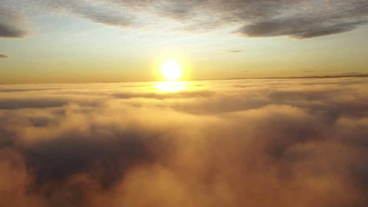 Drone shot in the cloud revealing the sun above the clouds