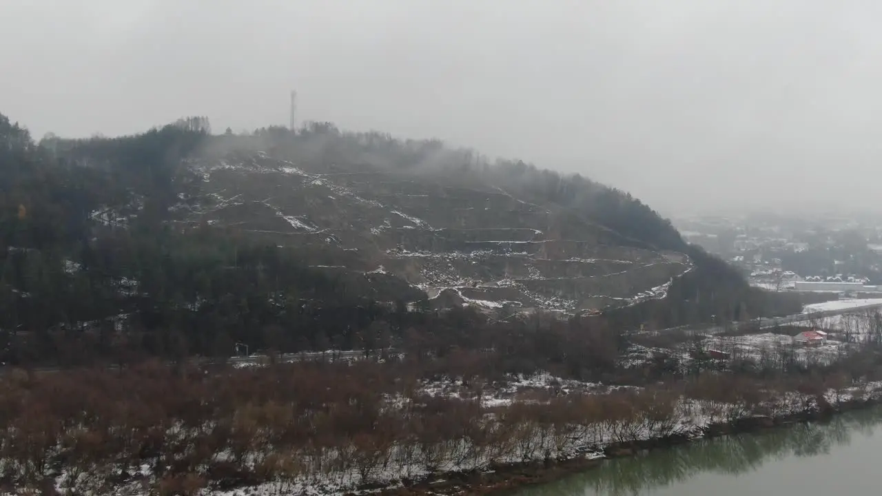 Quiet mountain valley in fog serene river in winter snowy scenery aerial panorama