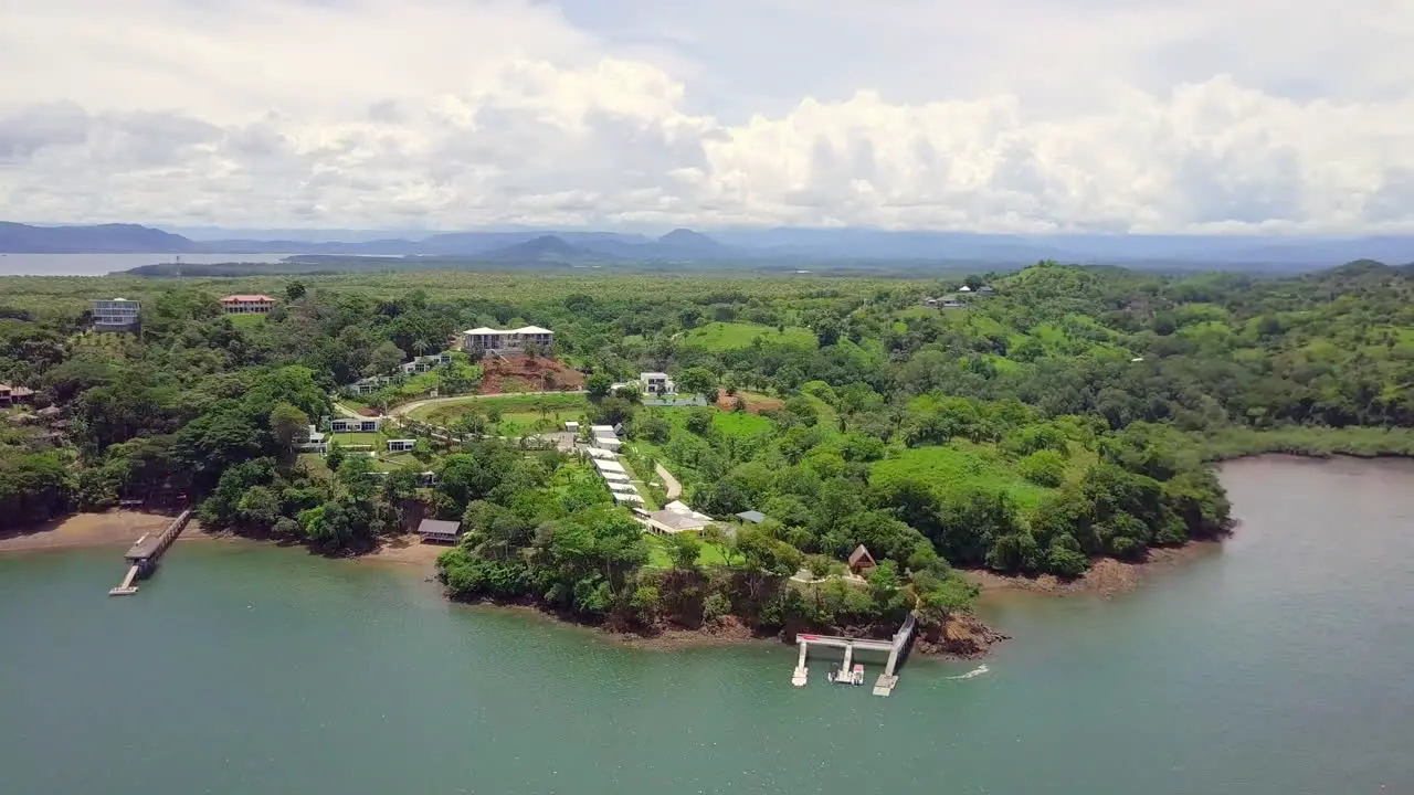 Horizontal drone shot of beautiful vacation location next to the sea in a forest with mountain and cloudy sky background Boca Chica Panama